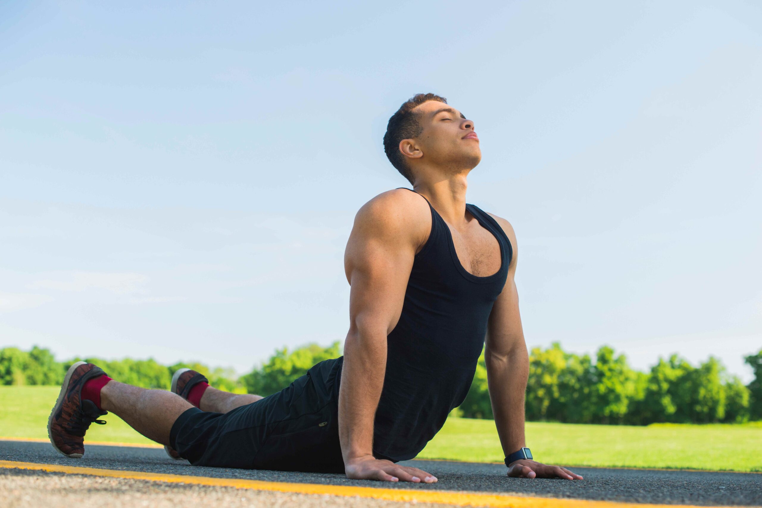 Athletic man practicing yoga outdoors