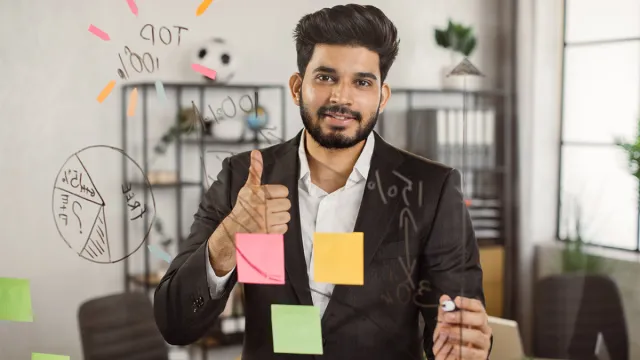 Person working at a desk with sticky notes and ideas